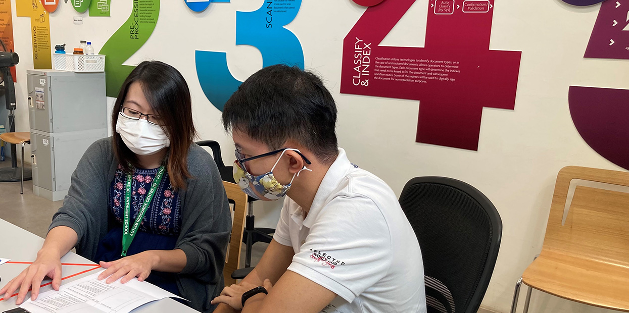 A job coach supporting an adult on the spectrum in preparation for employment